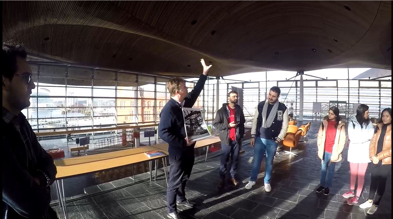 Students in Senedd building listening to Senedd staff giving information about the roof structure