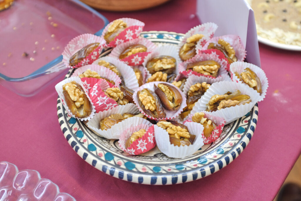 A blue decorative plate with dates stuffed with walnuts.